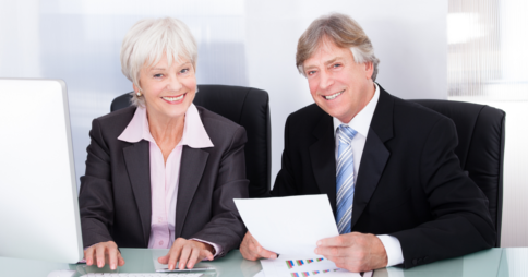 Elderly woman and man in office attire