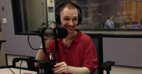Robert Kingett in the WEBZ studio, wearing headphones and sitting behind a microphone