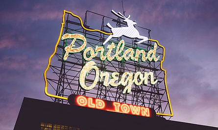 Neon sign reading "Portland, Oregon, Old Town" lit up at dusk