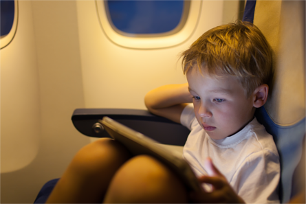 Young boy watching a tablet device in-flight