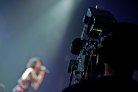 Cameraman recording a singer live on stage