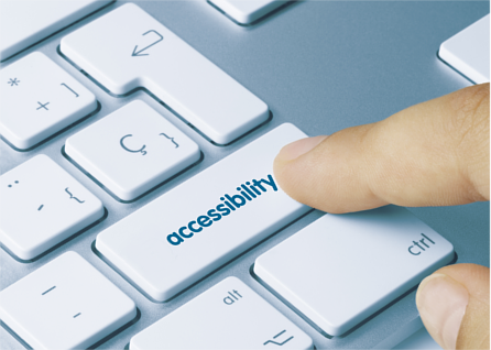 Finger resting on an accessibility button on a computer keyboard