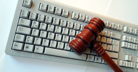 Wooden gavel resting on computer keyboard