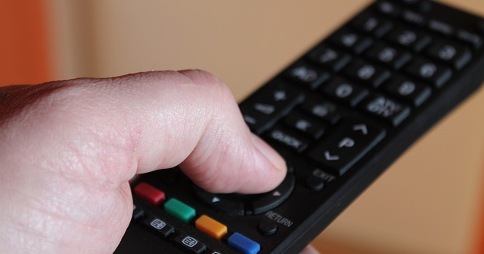 Left hand pressing 'up' button on remote control