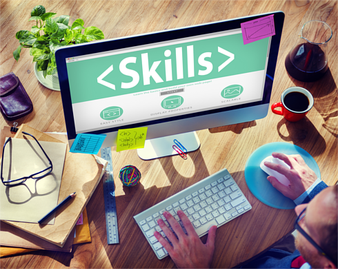 Man using a Mac computer with the word Skills displayed on screen Man using a Mac computer with the word Skills displayed on screen