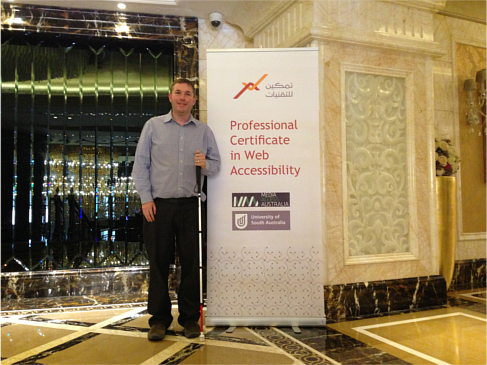 Dr Scott Hollier standing next to a Professional Certificate in Web Accessibility banner, containing the Tamkeen Technologies, Media Access Australia and University of South Australia logos Dr Scott Hollier standing next to a Professional Certificate in Web Accessibility banner, containing the Tamkeen Technologies, Media Access Australia and University of South Australia logos