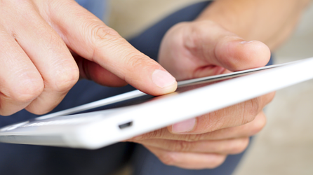 Man holding and pressing down on a tablet device